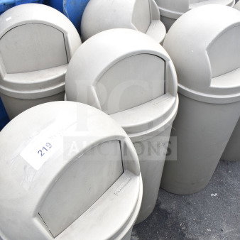 6 Tan Rubbermaid poly trash cans, dome lids, gently used. Label visible: "219". Auction: bid multiplies by 6.
