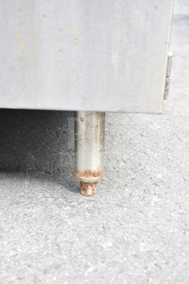 Commercial ice bin with metal exterior, visible wear on the leg. Ideal for storage, durable, and suitable for food service.