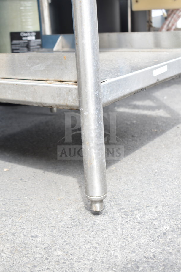 Stainless steel commercial table with ice bin, sturdy legs, and visible surface wear. Suitable for food service use.