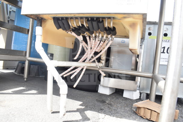 Commercial table with integrated ice bin, stainless steel frame, visible plumbing and tubing underneath, used condition.