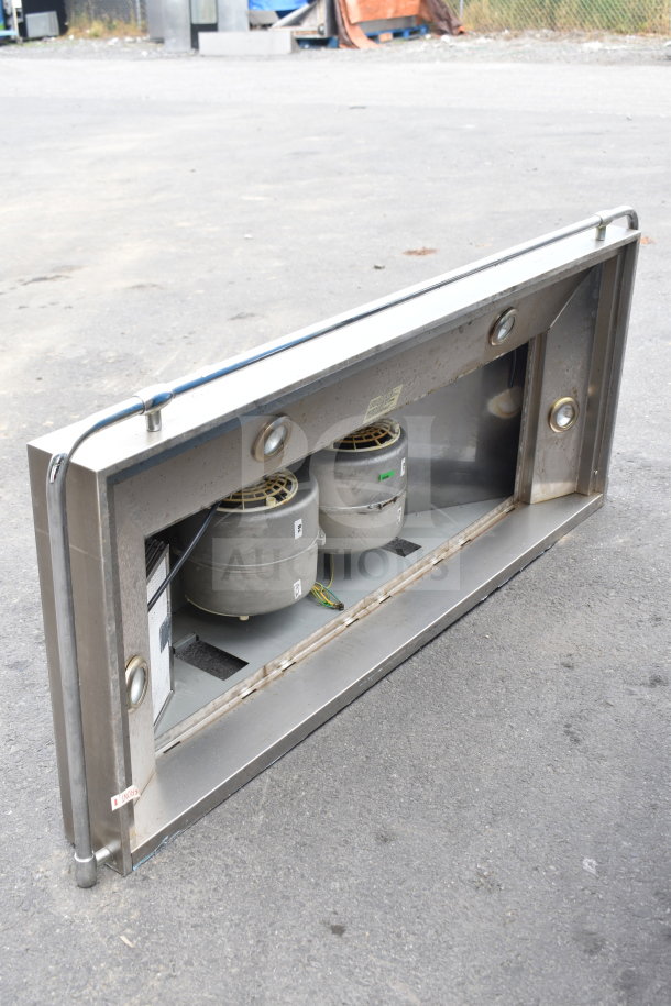 Stainless steel Broan range hood in used condition, featuring dual fans and integrated lighting. Visible wiring and mounting hardware.