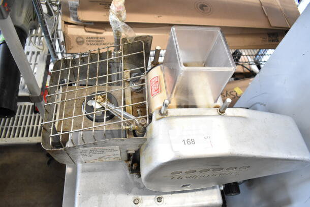 Hollymatic commercial countertop patty former machine on cart, 115 volts, 1 phase. Features metal grid, hopper, and identification label.