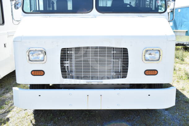2021 Ford Step Van, white front view, headlights and grille visible, VIN 1F66F5KN3M0A01361, parked on grass.