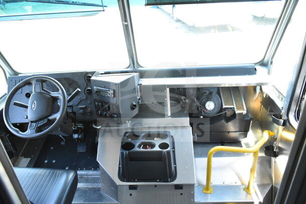 Interior view of 2021 Ford Step Van, showing steering wheel, dashboard controls, seating, and steps in good condition.