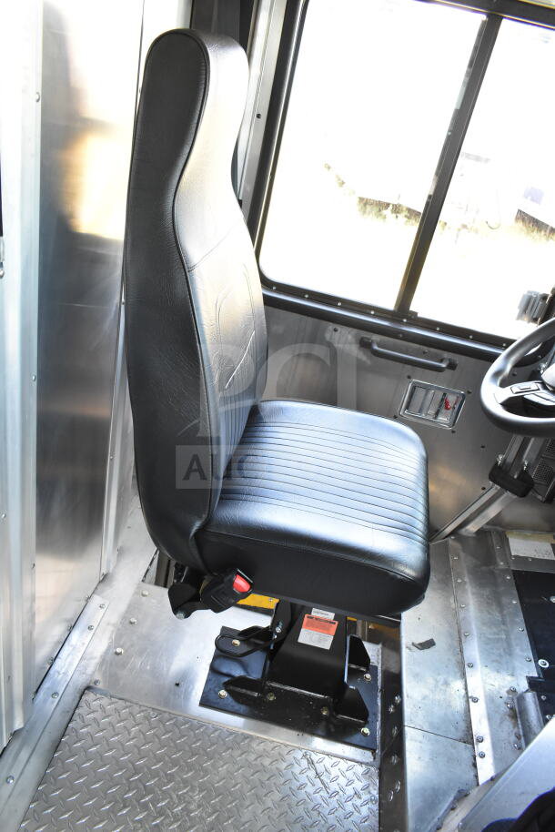 2021 Ford Step Van interior showing black driver's seat in excellent condition, metal flooring, and window.