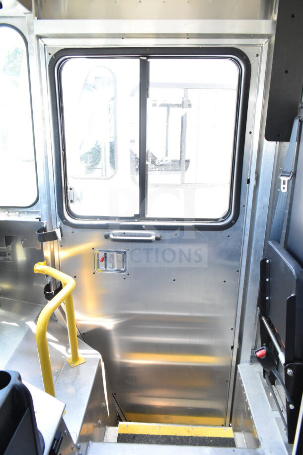 Interior view of a 2021 Ford Step Van, pristine condition, highlighting door and step features with safety handle. VIN 1F66F5KN3M0A01361.