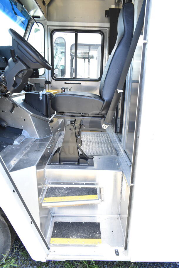 2021 Ford Step Van interior with driver's seat, steering wheel, metal steps with grip tape. VIN 1F66F5KN3M0A01361.