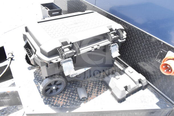 Black storage box with wheels and metal latches on the 2020 Southern Dimensions 8.5x28 food trailer surface.