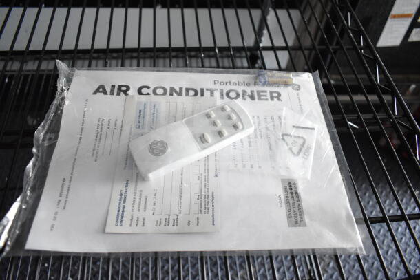 Air conditioner manual and remote on wire shelf; includes product and installation information.