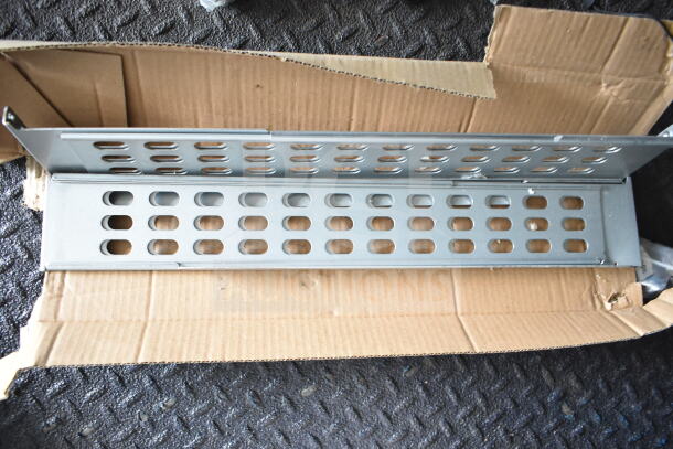 Metal ventilation panel in a cardboard box, featuring oval perforations for airflow, suitable for installation or repair use.