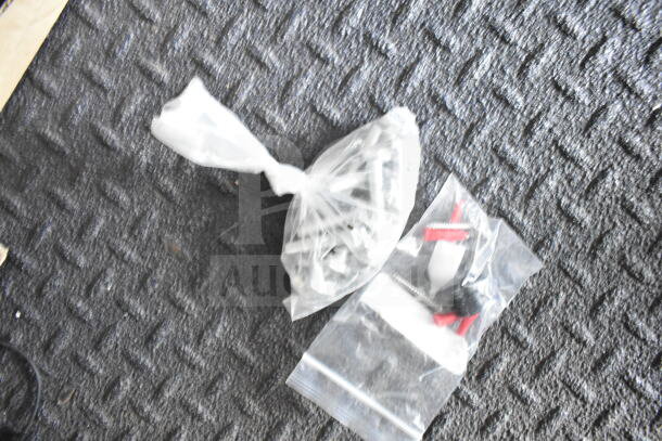 Plastic bags containing screws and small hardware on a textured surface.