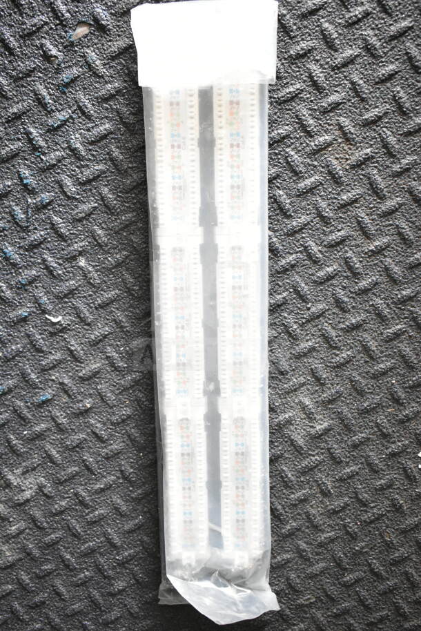 A packaged lighting strip with multicolored LED segments on a textured black surface.