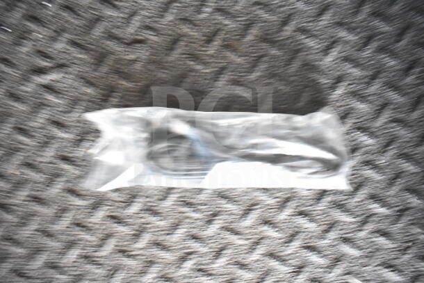 A plastic-wrapped cable on a textured surface, unclear focus.