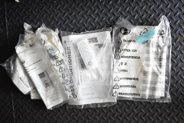 Plastic bags containing instruction manuals and a remote control for GE appliances, featuring multilingual warning labels.