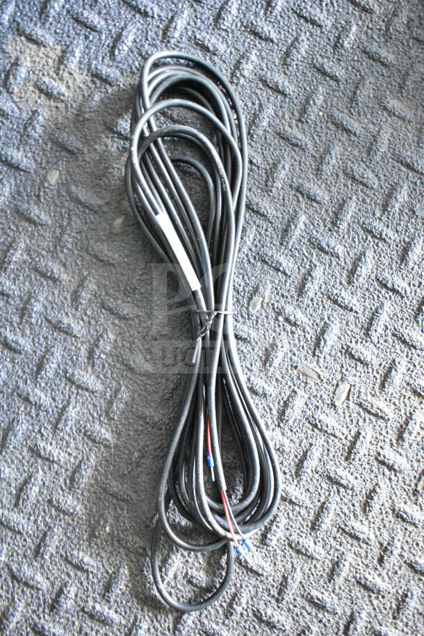 Coiled black cable on textured gray surface, secured with zip ties, showing multiple insulated wires.