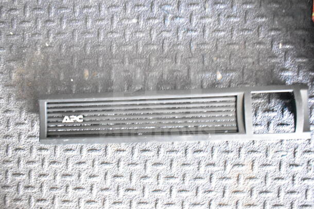 APC vented panel on black textured surface, possibly a component or accessory for refrigeration or electronic equipment.