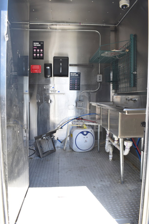 2021 Diamond Cargo 8.5x24 food trailer interior, stainless steel sink, water heater, and sanitation signs.