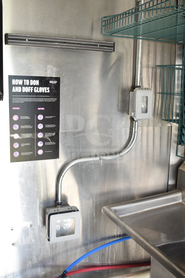 Interior of 2021 Diamond Cargo food trailer with stainless steel walls, electrical outlets, and wire shelving. Instructions for glove use visible.