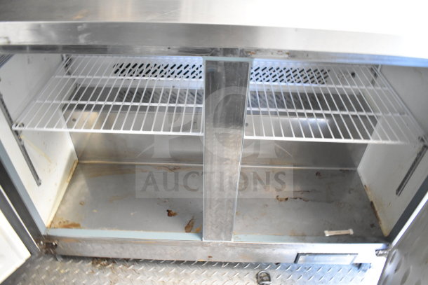 2021 Diamond Cargo food trailer; interior view showing shelves beneath kitchen prep area. Visible wear and cleanable surface.