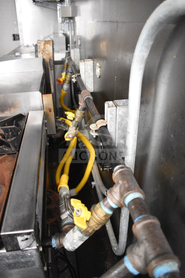 2021 Diamond Cargo food trailer interior showing gas lines, range, and stainless steel surfaces. Fully equipped.