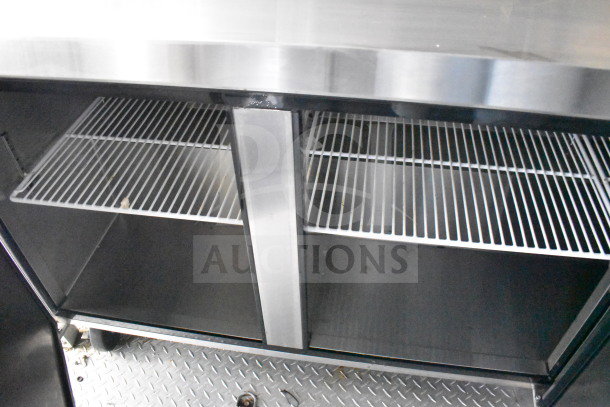 Interior view of a 2021 Diamond Cargo 8.5x24 food trailer's stainless steel cabinet with wire shelving, part of the fully outfitted kitchen.