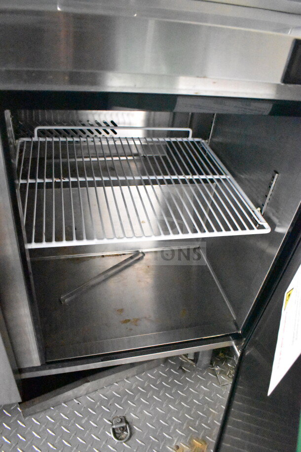 2021 Diamond Cargo 8.5x24 food trailer interior view showing stainless steel fridge with wire shelving and diamond plate flooring.