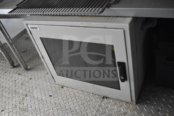 Diamond Cargo food trailer's interior showing a closed cabinet with a "martin" label, set against a textured floor.