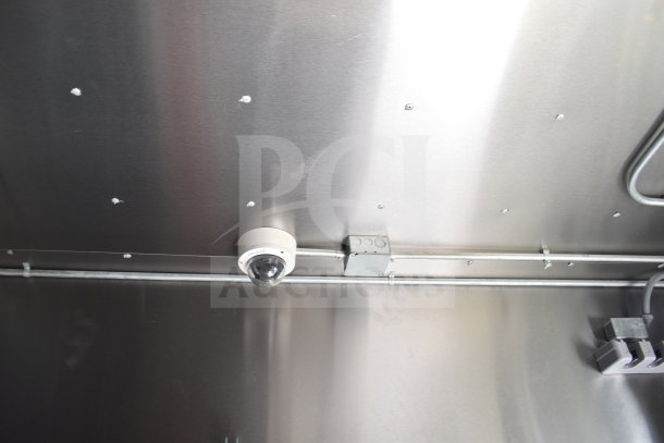 Interior of Diamond Cargo 8.5x24 food trailer with surveillance camera, wiring, and metal paneling. Includes VIN 53NBE2421M1089857.