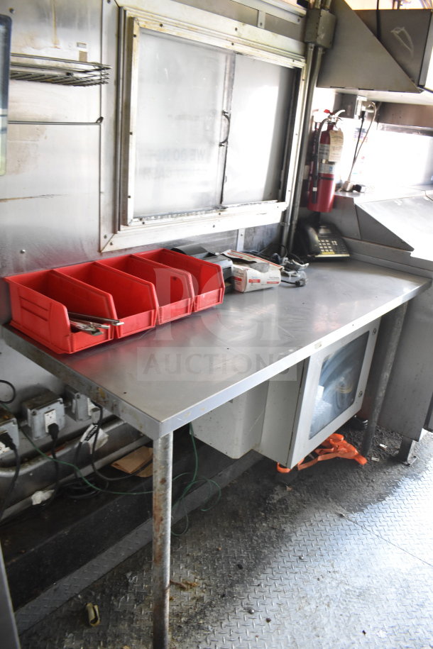 2020 Diamond Cargo 8.5x24 food trailer interior, showing stainless steel counter, red storage bins, and equipment.