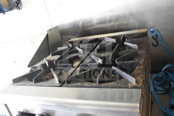 Dirty commercial stove top inside a 2020 Diamond Cargo 8.5x24 food trailer with grease hood. Wear evident.