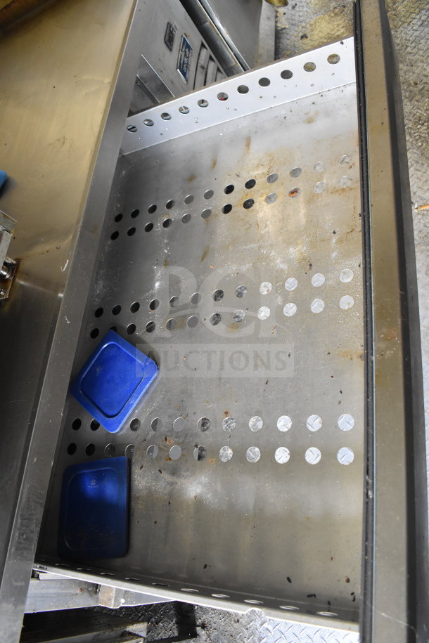 Interior view of 2020 Diamond Cargo 8.5x24 food trailer showing perforated metal shelf with minor wear, includes blue plastic trays.