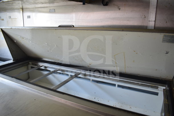 Interior view of 2020 Diamond Cargo 8.5x24 food trailer featuring a refrigeration unit under an opened lid, showing wear.