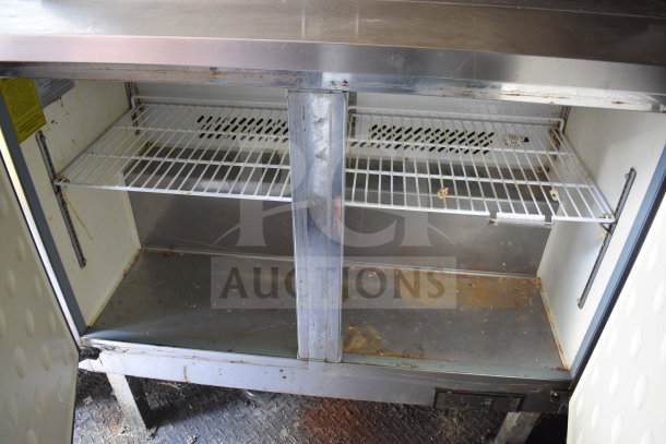 2020 Diamond Cargo 8.5x24 food trailer interior view, showing under-counter storage with wire shelving, slight wear visible.