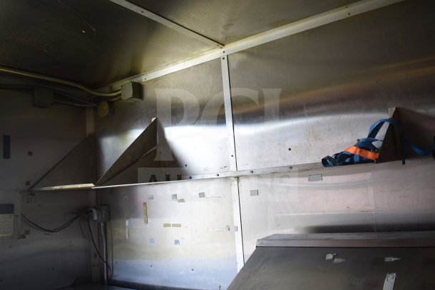 2020 Diamond Cargo 8.5x24 food trailer interior with grease hood, fryer setup, shelving, and metal walls. VIN: 53NBE2427L1083687.