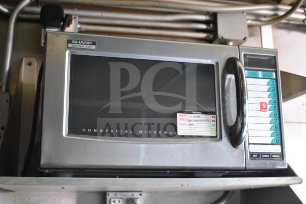 Sharp commercial microwave model R-21LV, visible control panel, and dessert menu stickers. Used in food trailer.