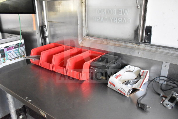 2020 Diamond Cargo 8.5x24 food trailer interior with red trays, electrical plug, and foil sheets. Stainless steel counter. VIN 53NBE2427L1083687.