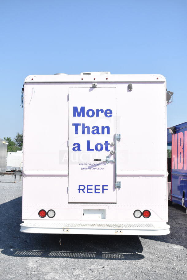 2020 Ford F59 food truck, white exterior, "More Than a Lot" sign, REEF branding, back view, good condition.