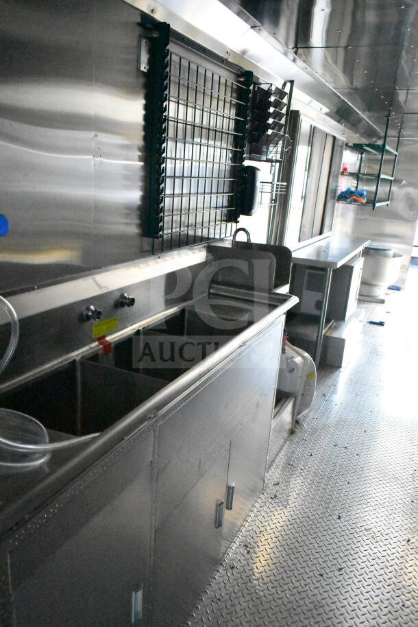 2020 Ford F59 food truck interior, featuring stainless steel sink, prep area, shelves, and clean diamond plate flooring.
