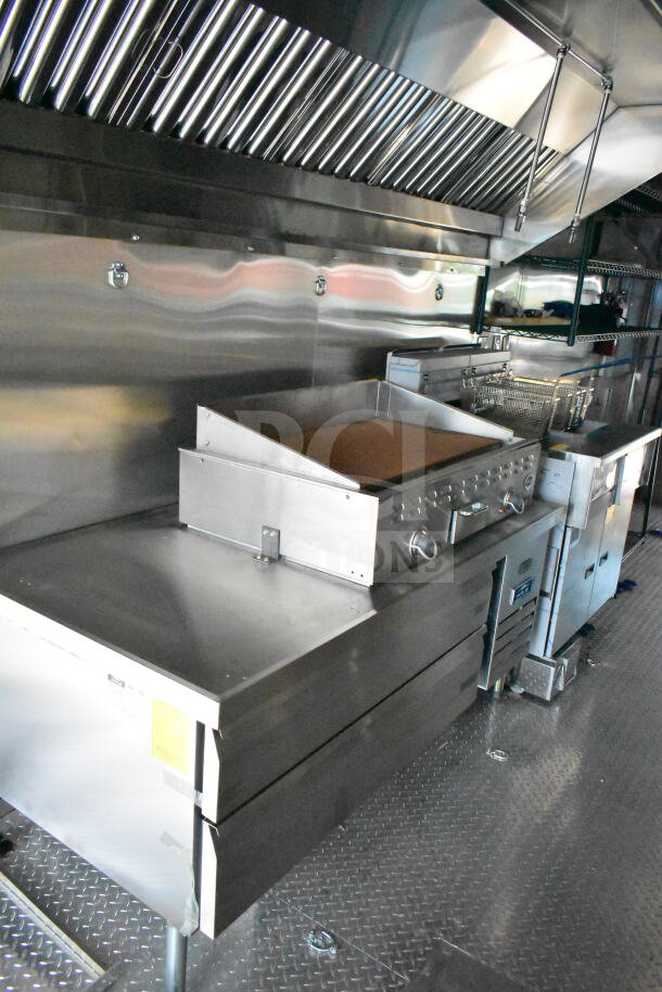2020 Ford F59 food truck interior, featuring stainless steel griddle, fryer, and storage units, in excellent condition.