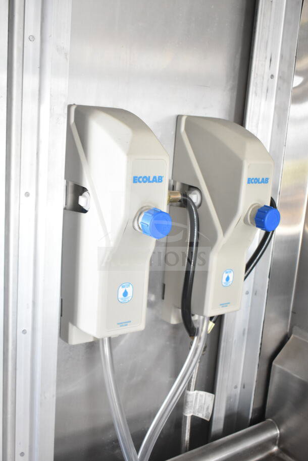 Two Ecolab water dispensers with blue knobs mounted on a metallic wall in a 2020 Ford F59 food truck.