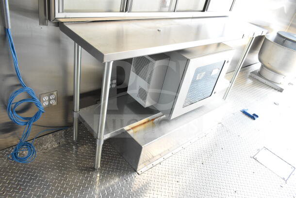 Stainless steel interior of 2020 Ford F59 food truck, showing shelving, outlets, and a vent near a wall.