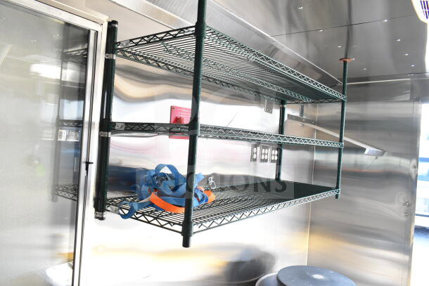 Interior of 2020 Ford F59 Food Truck with metal shelving, visible blue and orange straps, and stainless-steel walls.