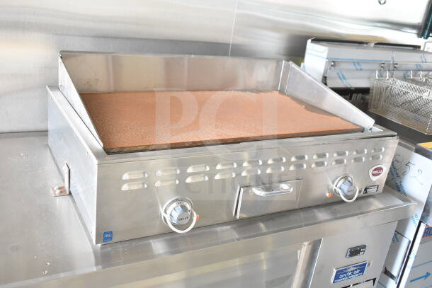 Stainless steel Wells griddle on a chef base in a 2020 Ford F59 food truck, featuring dual control knobs.