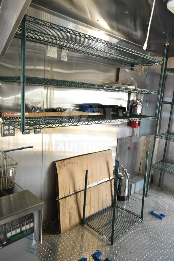 Interior of 2020 Ford F59 food truck with shelves, fryer, grease hood, and fire suppression system. Clean and well-equipped.