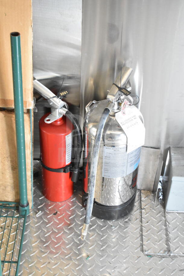 Fire extinguishers inside a 2020 Ford F59 food truck, with labels visible showing inspection dates and service tags.