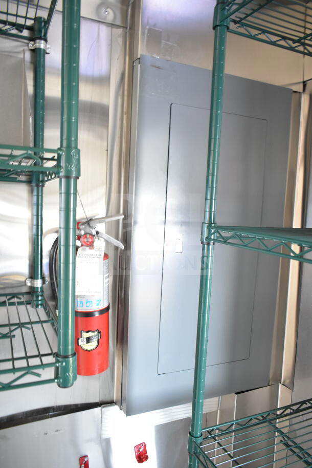 Interior view of 2020 Ford F59 food truck featuring wired shelving, fire extinguisher, and electrical panel.