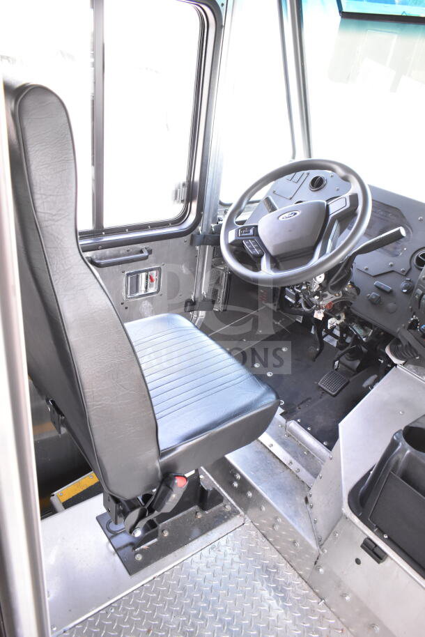 2020 Ford F59 food truck interior with driver's seat and steering wheel. Features include grease hood, Pitco fryer.