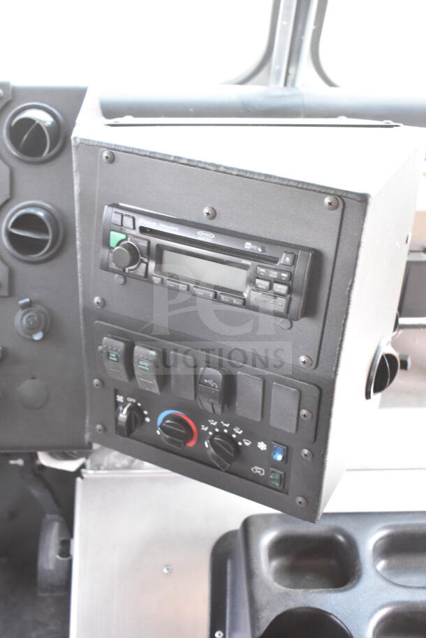 Dashboard controls of a 2020 Ford F59 Food Truck, featuring a stereo and climate control panel.