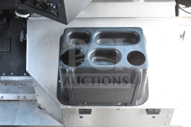 Interior of 2020 Ford F59 food truck, showing cupholder and dashboard controls.