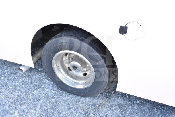 2020 Ford F59 Food Truck wheel and side body detail, showing tire and exhaust pipe.